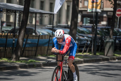 Man riding bicycle on road in city