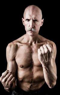 Portrait of man against black background