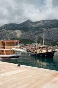 Sailboats moored on sea against sky