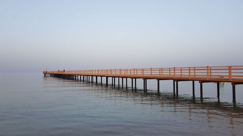 Pier over sea against clear sky