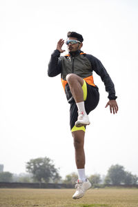 Young indian boy exercising and jumping on the sports field. sports and healthy lifestyle concept.