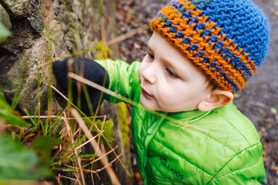 A young boy observing plants and insects on a nature walk