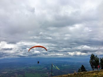 Woman flying over mountain against sky