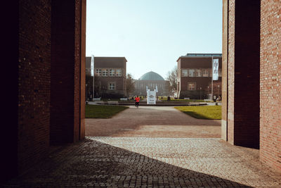 Street amidst buildings against clear sky