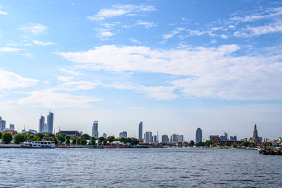 River by city buildings against sky