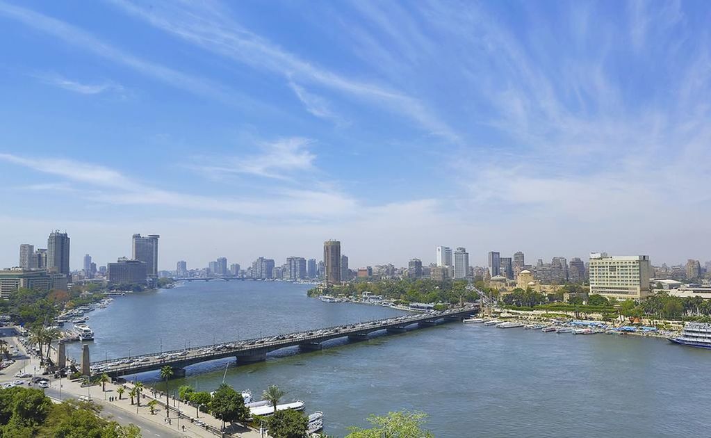 SCENIC VIEW OF RIVER BY BUILDINGS AGAINST SKY