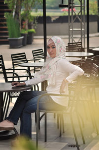 Young woman sitting at outdoors cafe