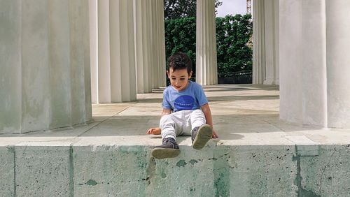 Full length of boy sitting outdoors