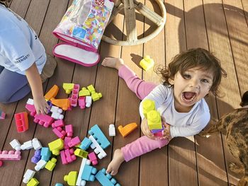 High angle view of girl shouting while playing with toys