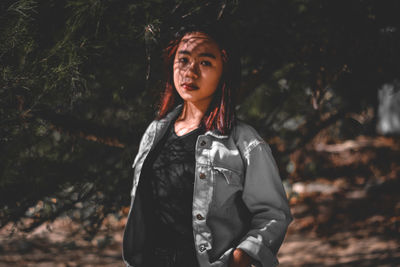 Portrait of beautiful young woman standing in forest