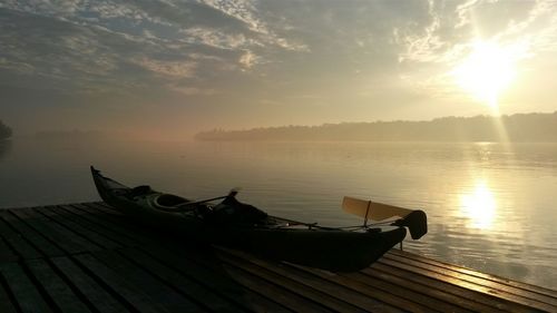 Boats in sea at sunset