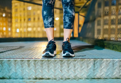 Low section of woman standing on footpath