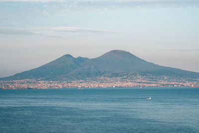 Scenic view of sea and mountains against sky