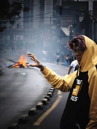 Woman standing by fire in city