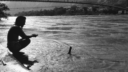 Side view of man fishing in lake