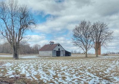 Barn in snowy speckled field 