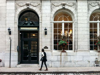 Rear view of woman walking in front of building