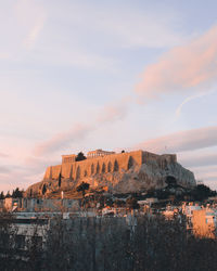 Buildings against cloudy sky at sunset