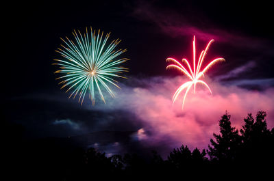 Low angle view of fireworks against sky at night