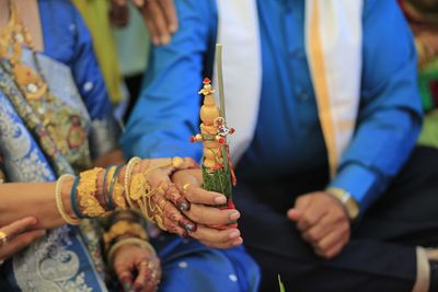 Midsection of newlywed couple holding object