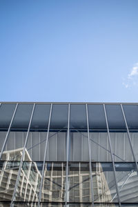 Low angle view of modern building against blue sky