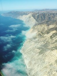 Scenic view of sea and mountains against sky