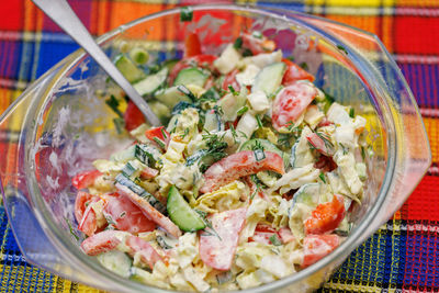 Vegetable salad with mayonnaise sauce in glass bowl