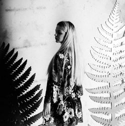 Portrait of woman standing against wall