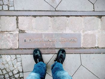 Low section of man standing on pavement