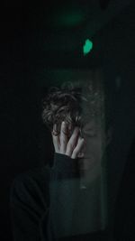 Portrait of young man against black background