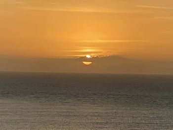 Scenic view of sea against orange sky