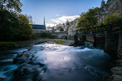 River flowing amidst buildings against sky
