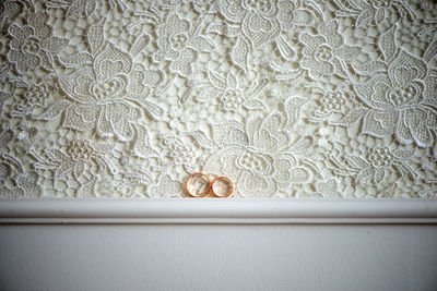 Close-up of rings on white wall
