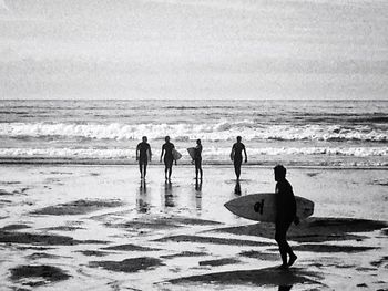 People at beach against sky