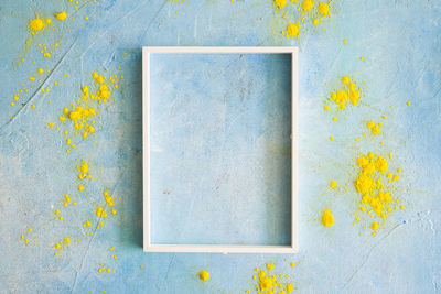 Close-up of yellow flowers on blue wall