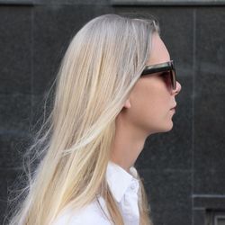 Close-up of woman looking away while standing against wall