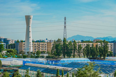 Buildings by swimming pool against sky