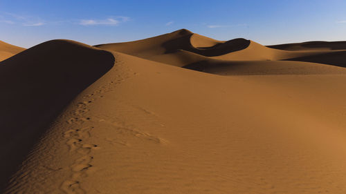 Sand dune in desert against sky