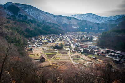 High angle view of buildings on field against mountains