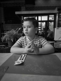 Cute boy sitting at restaurant table