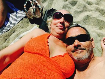 Portrait of happy couple lying on beach