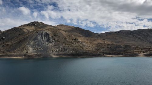 Scenic view of lake by mountains against sky