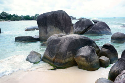 Close-up of rocks on shore against sky