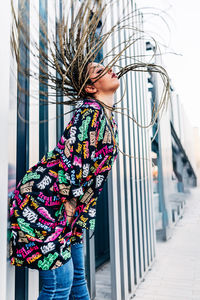 Side view of woman standing by building