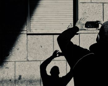Shadow of man photographing on mobile phone