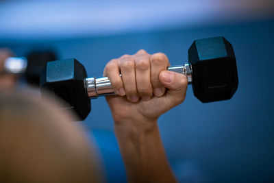 Hand holding dumbbells in gym