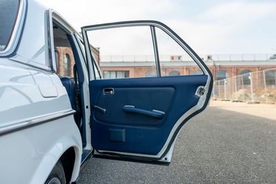 Open car door with a brick building in the background