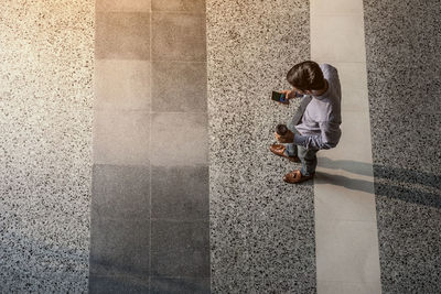 High angle view of businessman standing while using smart phone