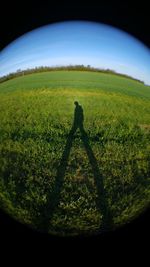 People on grassy field against sky