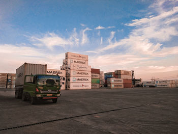 Cars on road by buildings against sky